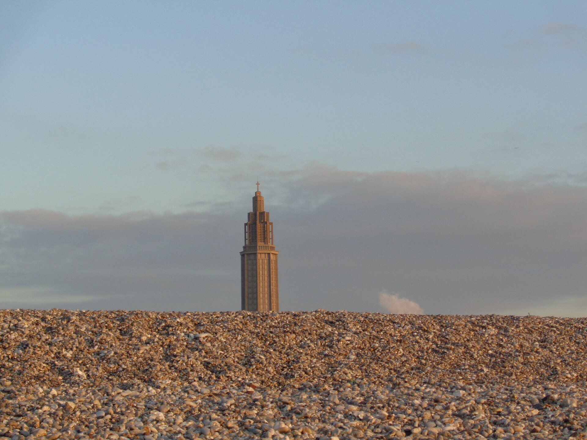 La plage de galets du Havre et la tour de l'église Saint-Joseph au couchant